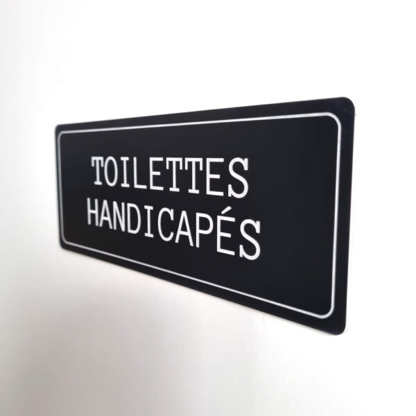 Plaque de porte toilettes handicapés en plastique de couleur noir fixation par adhésif 3M