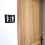 Plaque pictogramme toilettes hommes femmes en aluminium anodisé noir fixation par adhésif 3M